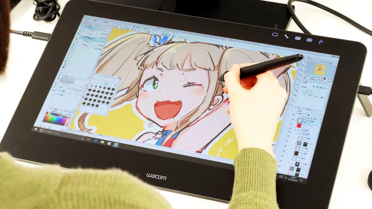 someone drawing a manga girl on a wacom drawing tablet