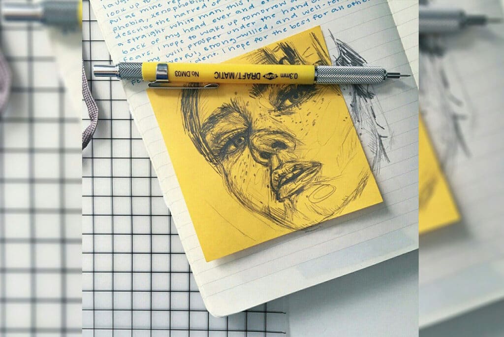 a cool yellow post-it in a notebook with a drawing of a girl on top of it 