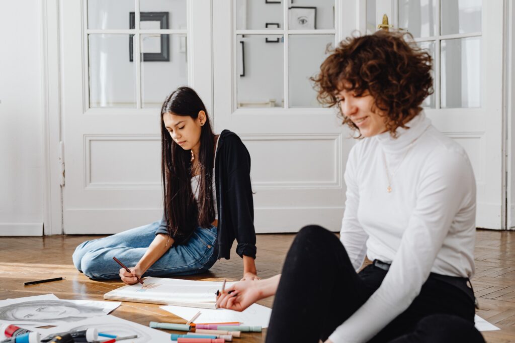 Two girls drawing on the floor